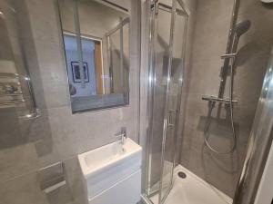 ein Badezimmer mit Dusche, Waschbecken und Spiegel in der Unterkunft Neon Heights 2 bed Luton town centre in Luton + 18 Fotos