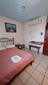 Un dormitorio con una cama y una mesa. en HOTEL CARMELITAS 42 en Villahermosa