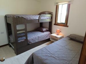 1 Schlafzimmer mit 2 Etagenbetten und 1 Bett in der Unterkunft Refugio las Quemas in Futrono