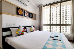 a bedroom with a large bed and a large window at OYO Home Elegant Stay Hiranandani in Mumbai