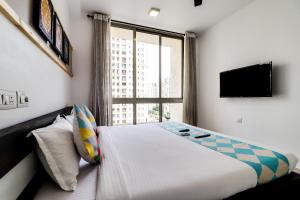 a bedroom with a bed and a large window at OYO Home Elegant Stay Hiranandani in Mumbai