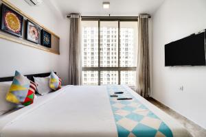 a bedroom with a large bed and a flat screen tv at OYO Home Elegant Stay Hiranandani in Mumbai