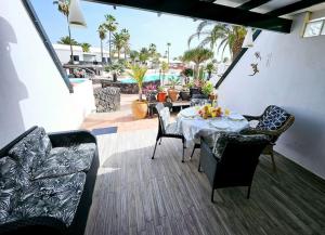 a patio with a table and chairs and a pool at Apartamento TAISA Playa Roca in Costa Teguise