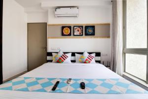a bedroom with a bed with two remote controls on it at OYO Home Elegant Stay Hiranandani in Mumbai