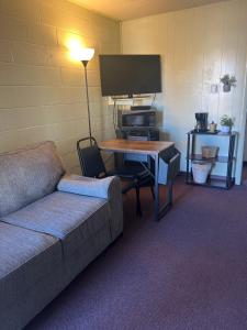 a living room with a couch and a table with a tv at Midtown Inn & Suites in La Junta