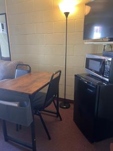 a room with a table with a microwave and a lamp at Midtown Inn & Suites in La Junta