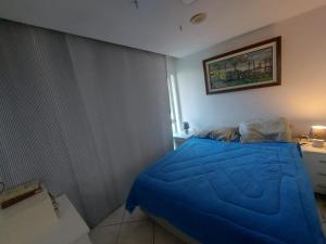 a small bedroom with a blue bed in it at Apartamento frente mar - Barra da Tijuca in Rio de Janeiro +3 photos