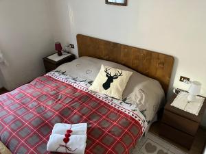 a bedroom with a bed with a red blanket and two night stands at Affittacamere Iragidor in Cortina dʼAmpezzo