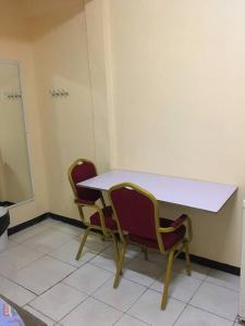 twee stoelen zitten rond een tafel in een kamer bij Hotel Mangueira in Paramaribo