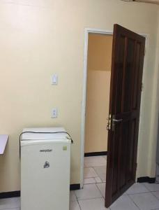 an open door to a room with a refrigerator at Hotel Mangueira in Paramaribo