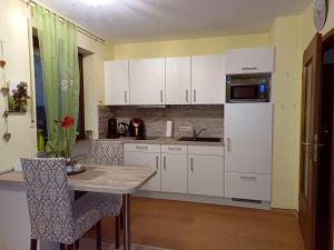 une cuisine avec des armoires blanches et une table avec des chaises dans l'établissement Ferienwohnung Lastro, à Cochem