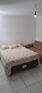 1 dormitorio con 1 cama y 1 sofá en Flat em Itamaracá en Itamaracá