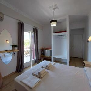 ヴァシリキにあるVilla Delfiniのベッドルーム1室(白いベッド1台、タオル付)