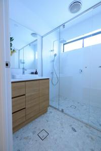 a bathroom with a shower and a sink and a mirror at Neddidge in Albury