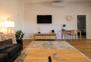 a living room with a couch and a tv on a wall at Neddidge in Albury