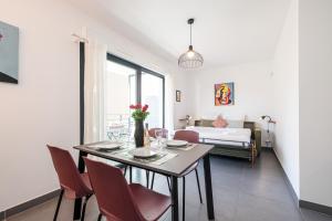 a dining room with a table and chairs and a bed at Queen Riviera : climatisation, parking, terrasse in Menton +36 photos