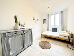 ein weißes Schlafzimmer mit einem Bett und einem Fenster in der Unterkunft L'échappée Belle in Laon