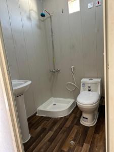 a bathroom with a toilet and a sink and a shower at كوخ الملاذ الريفي MalathCottage in AlUla