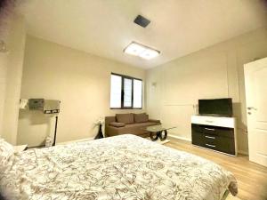 a bedroom with a bed and a couch and a television at Nataly New luxury apartment on Black sea in Varna City