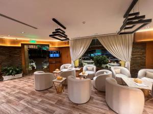 السعادة سويت - الملز الرياض Saada Suites Serviced Apartments في الرياض: غرفة انتظار مع كراسي وطاولات بيضاء