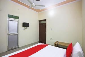 OYO 62761 Hotel Daksh في Mahendragarh: غرفة نوم مع سرير مع مروحة سقف ونافذة