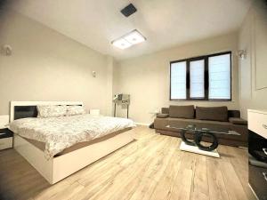 a bedroom with a bed and a couch at Nataly New luxury apartment on Black sea in Varna City
