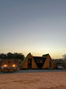 eine Hütte in der Wüste mit Sonnenuntergang im Hintergrund in der Unterkunft كوخ الملاذ الريفي MalathCottage in Al-'Ula