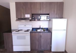 a kitchen with a white refrigerator and a sink at Travelodge by Wyndham Valleyview AB in Valleyview +12 photos