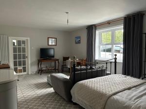 een slaapkamer met een bed en een woonkamer met een televisie bij Caistor Bed & Breakfast in Caistor