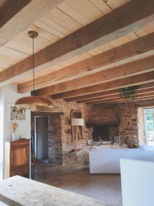 uma sala de estar com uma lareira de pedra e uma mesa em Maison Béganne - Nature & Charme em Béganne