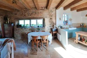 uma cozinha com uma mesa e uma parede de pedra em Maison Béganne - Nature & Charme em Béganne