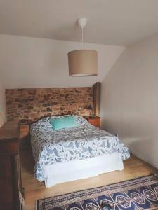 um quarto com uma cama com um edredão azul e branco em Maison Béganne - Nature & Charme em Béganne