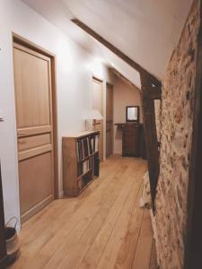 um quarto vazio com uma parede de pedra e pisos de madeira em Maison Béganne - Nature & Charme em Béganne