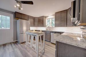 uma cozinha com armários de madeira e um frigorífico branco em Trendy Getaway: Pet-Friendly + 5 Min to Downtown em Milwaukee