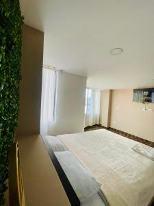 um pequeno quarto com uma cama e uma janela em TRÉBOL GOLDEN HOTEL em Ipiales