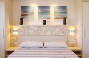 een slaapkamer met een bed met vier foto's aan de muur bij Asinara Appartment in Sorso