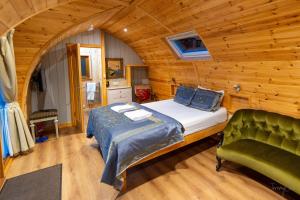 a bedroom with a bed and a green chair at Missin' Link Glamping in West Hoathley