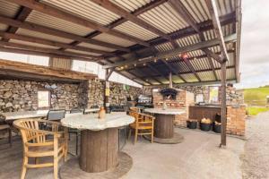 un patio esterno con tavoli, sedie e griglia di Mayo Glamping a Castlebar