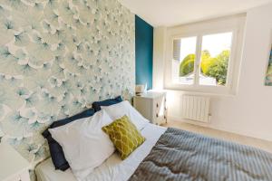 1 dormitorio con 1 cama con pared de flores en A1, en Évaux-les-Bains