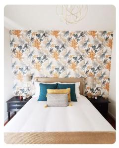 - une chambre avec un lit blanc et un papier peint floral dans l'établissement Apartamento céntrico con parking y wifi gratis, à Oviedo