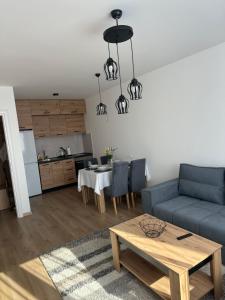 - un salon avec un canapé bleu et une table dans l'établissement Lux Apartment 31, à Lukavica
