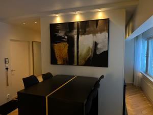 une salle à manger avec une table et un tableau mural dans l'établissement Rewell Suite - Central location and nice view!, à Vaasa
