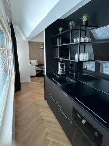 una cocina con encimera negra y fregadero en Rewell Suite - Central location and nice view! en Vaasa