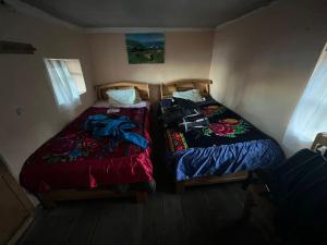 two beds sitting next to each other in a room at MOON NIGHT Amantani Lodge in Ocosuyo