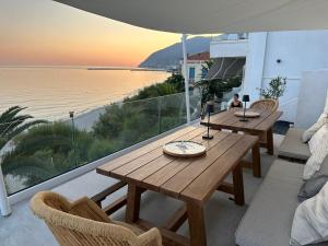 salon ze stołem i widokiem na ocean w obiekcie Sofi Mar - Plomari - The place to be w mieście Plomari