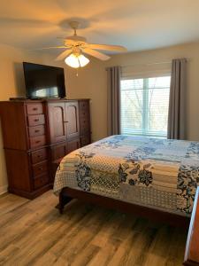 a bedroom with a bed and a dresser and a television at Bill’s On Little Pigeon River in Pigeon Forge