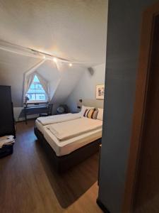 ein Schlafzimmer mit einem großen Bett im Dachgeschoss in der Unterkunft Gasthaus Sonne GbR in Trennfeld