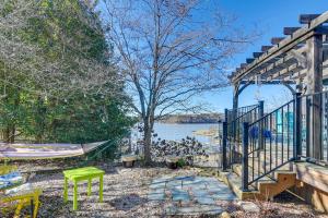 a porch with a hammock and a lake at Lakefront Radford Home with Wraparound Deck! in Radford
