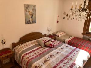 a bedroom with two beds and a chandelier at Ciasa Nonna Bon Bon in Cortina dʼAmpezzo