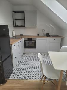 a kitchen with white cabinets and a black and white tile floor at Gościniec Pokoje Noclegowe Drawsko Pomorskie in Drawsko Pomorskie